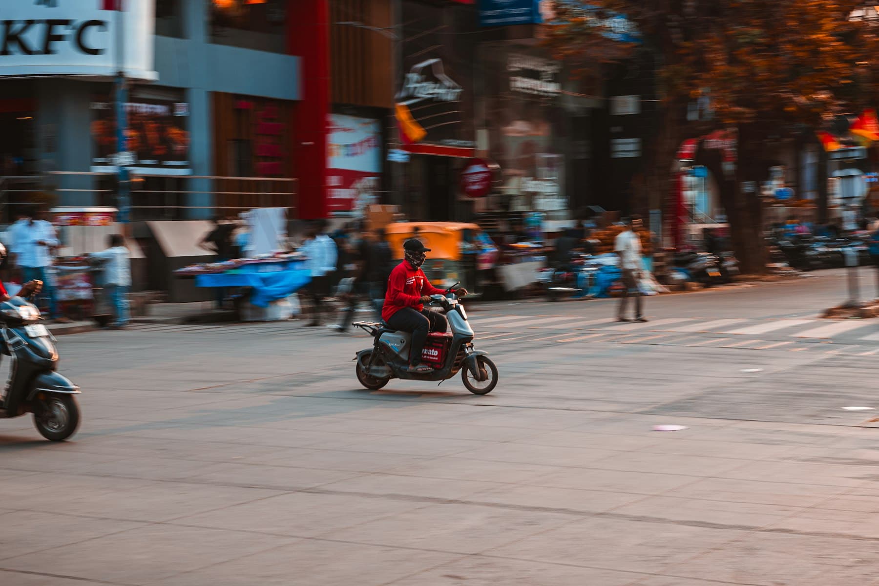 A rider on a scooter crossing a busy Bengaluru street